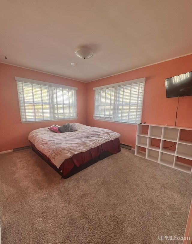 carpeted bedroom featuring multiple windows and a baseboard radiator