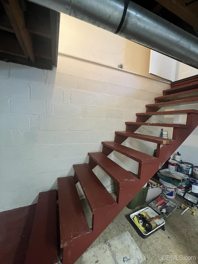 staircase featuring concrete block wall