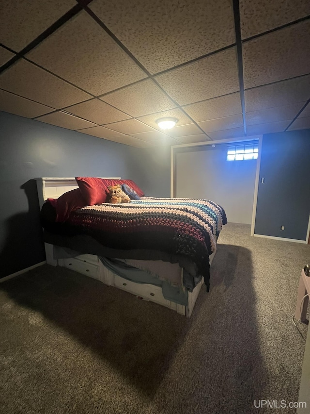 bedroom with a drop ceiling and carpet flooring