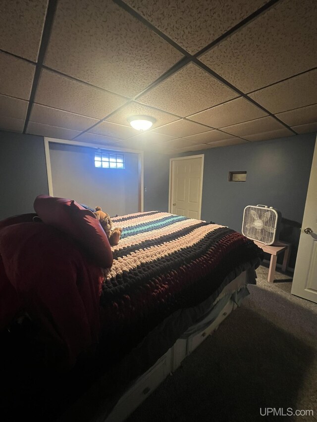 carpeted bedroom featuring a drop ceiling