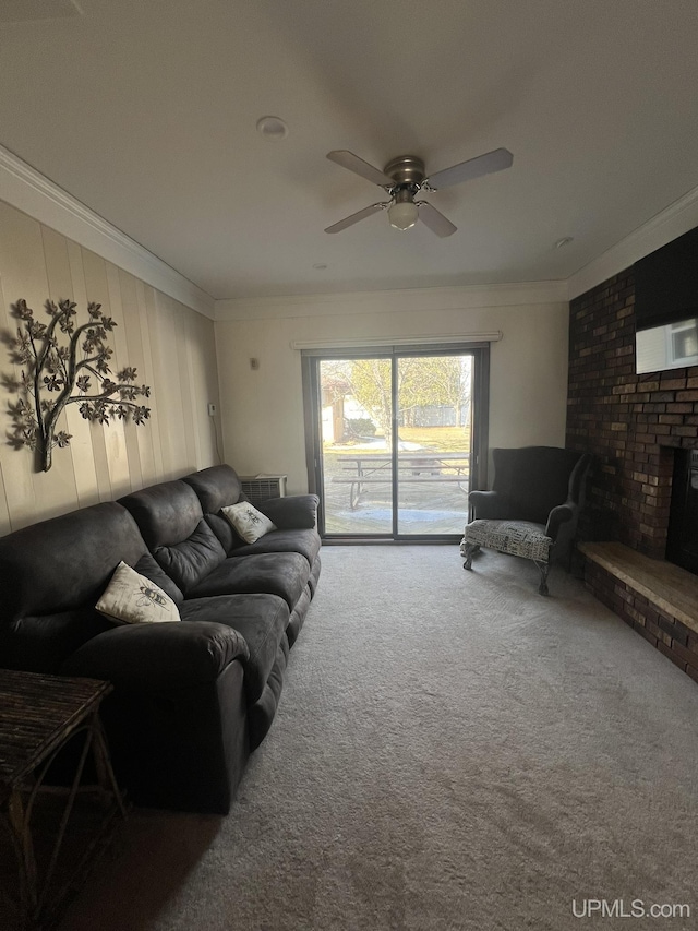 carpeted living area with a fireplace, crown molding, and a ceiling fan