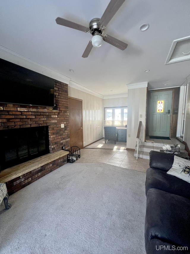 tiled living room featuring a ceiling fan, a fireplace, carpet floors, and ornamental molding