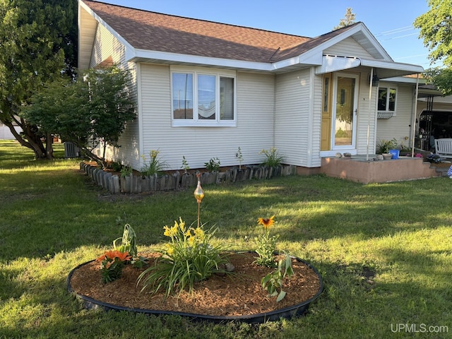 view of front of property featuring roof with shingles and a front yard