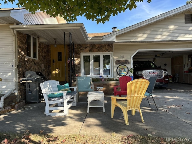 view of patio with a garage, driveway, and a grill