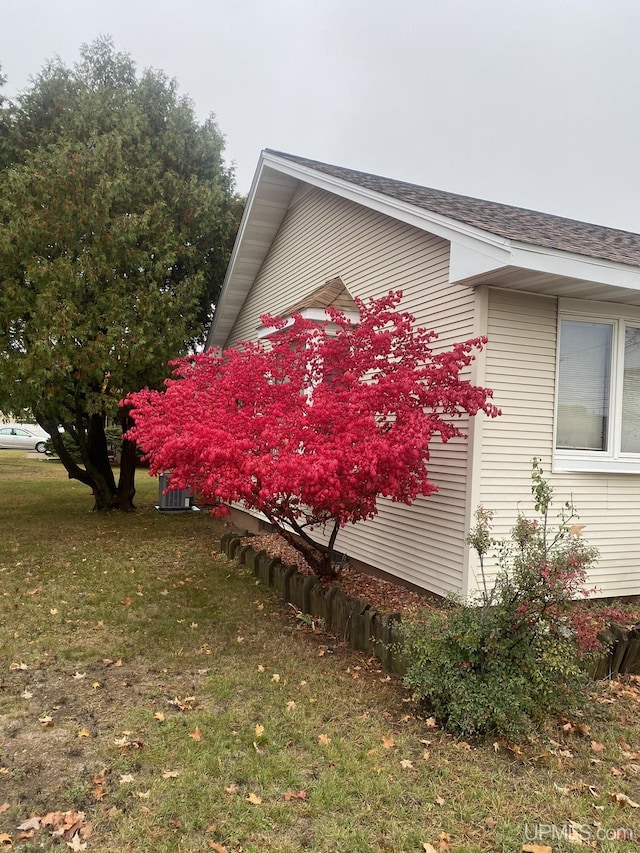 view of side of home with a yard