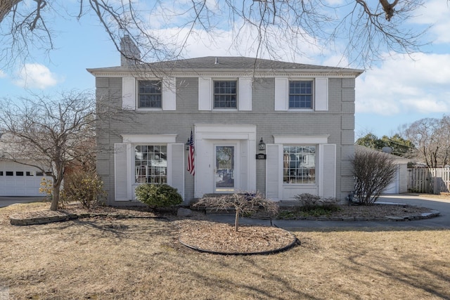 colonial house featuring a garage, a front yard, and driveway