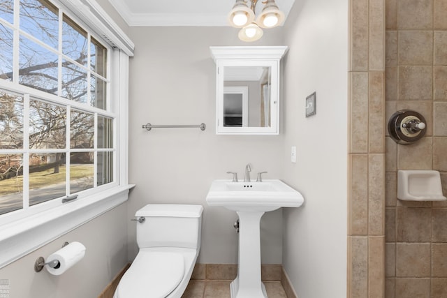 full bathroom featuring tile patterned flooring, crown molding, toilet, a tile shower, and a notable chandelier