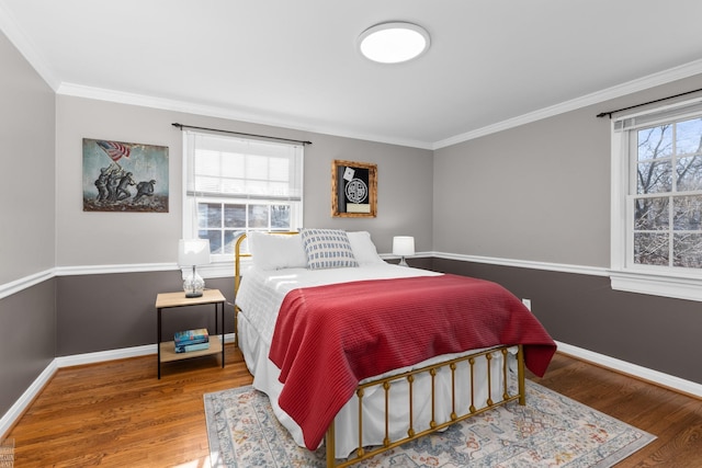 bedroom with baseboards, wood finished floors, and crown molding