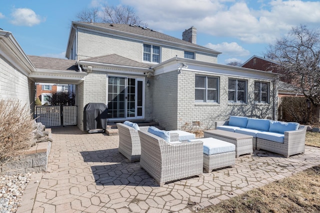 rear view of property with brick siding, a patio area, an outdoor hangout area, and a chimney