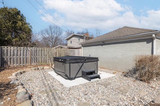 view of yard featuring a hot tub and a fenced backyard