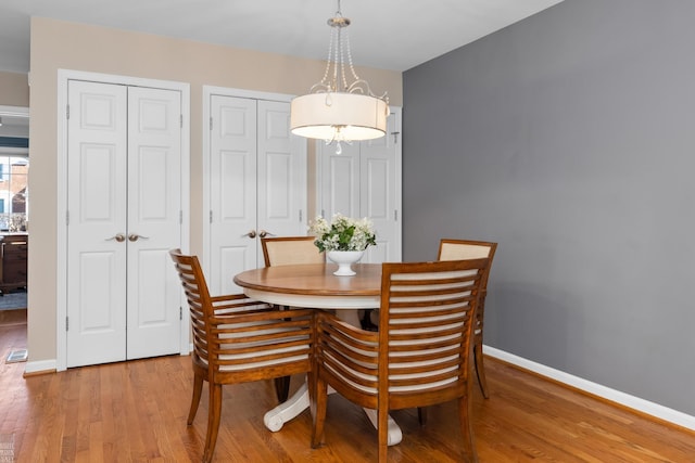 dining area with light wood-style floors and baseboards