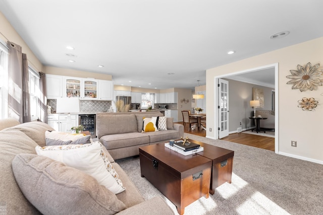 living room featuring a wealth of natural light, baseboards, wine cooler, and recessed lighting