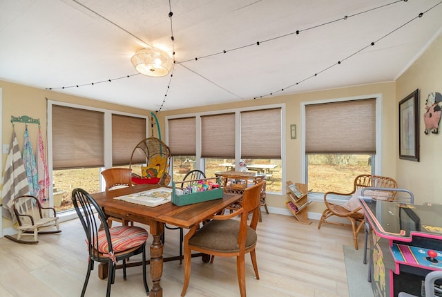 dining room featuring baseboards and light wood-type flooring