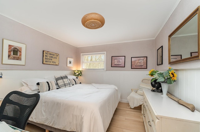 bedroom with light wood finished floors and ornamental molding