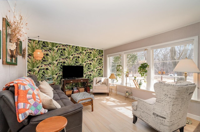 living room featuring light wood-style flooring, wallpapered walls, and baseboards