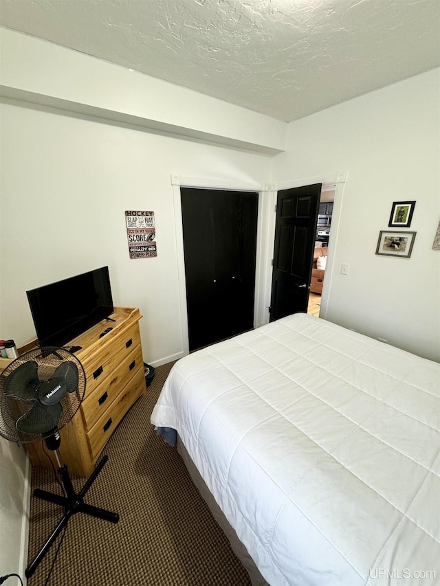 carpeted bedroom featuring a textured ceiling