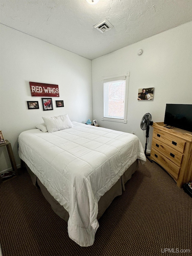 carpeted bedroom featuring visible vents, a textured ceiling, and baseboards