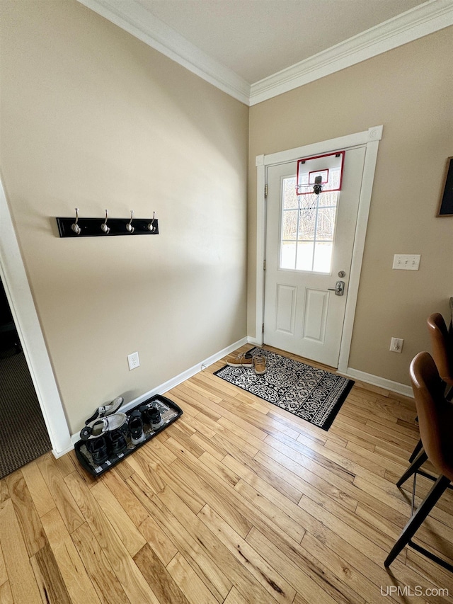 foyer featuring wood finished floors, baseboards, and ornamental molding