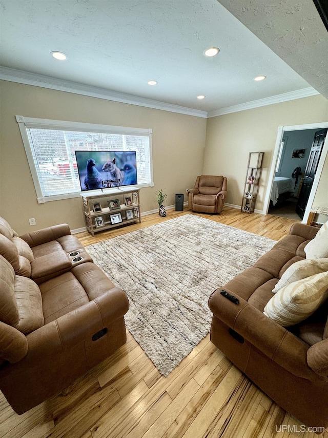 living area featuring wood finished floors, a wealth of natural light, and ornamental molding