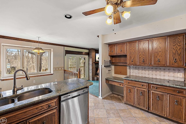 kitchen featuring ceiling fan, decorative light fixtures, dishwasher, brown cabinetry, and a sink