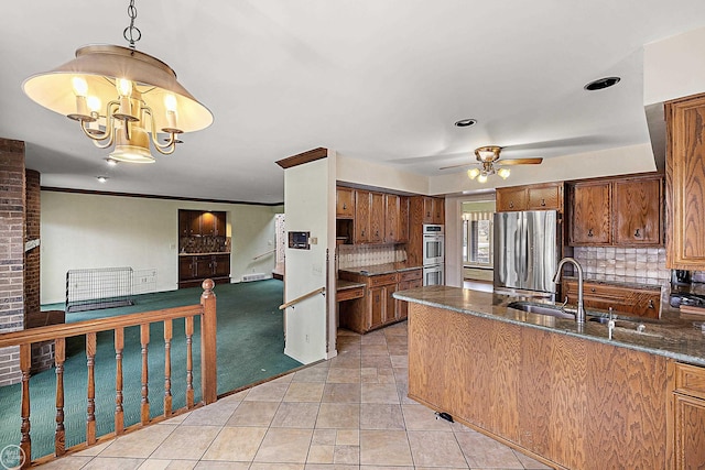 kitchen featuring a sink, decorative backsplash, brown cabinets, and appliances with stainless steel finishes