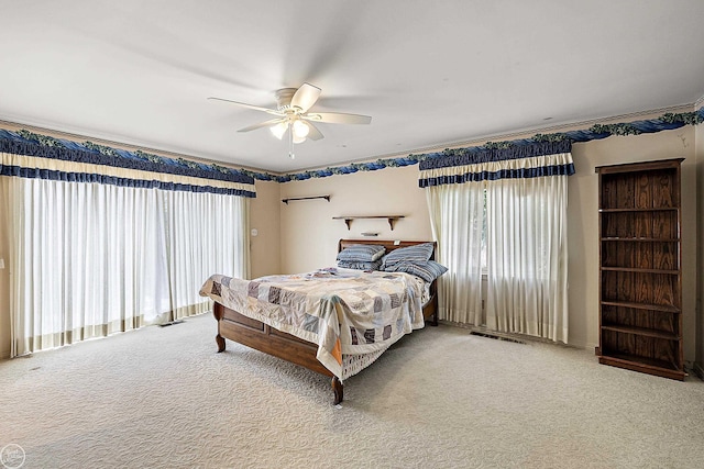 carpeted bedroom featuring a ceiling fan and visible vents