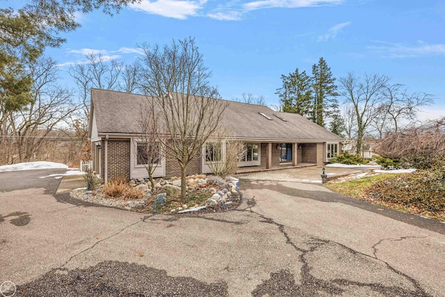 ranch-style house with aphalt driveway and brick siding