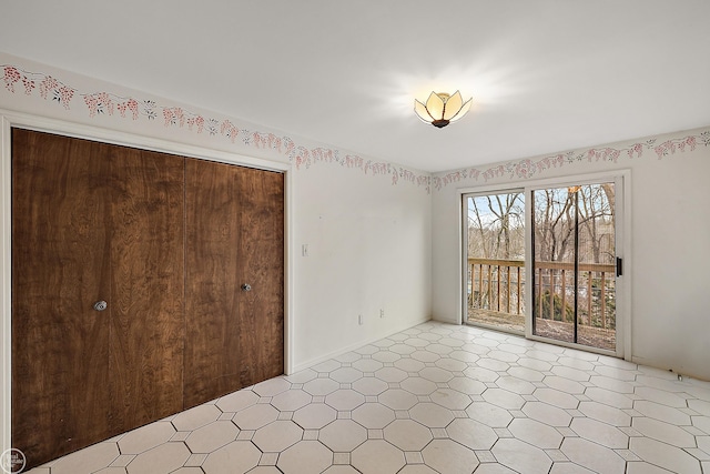 unfurnished bedroom featuring access to exterior, light floors, and a closet