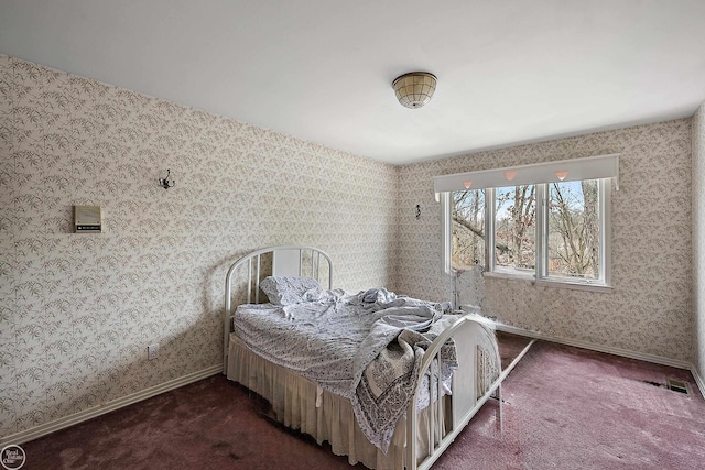 carpeted bedroom with visible vents, baseboards, and wallpapered walls