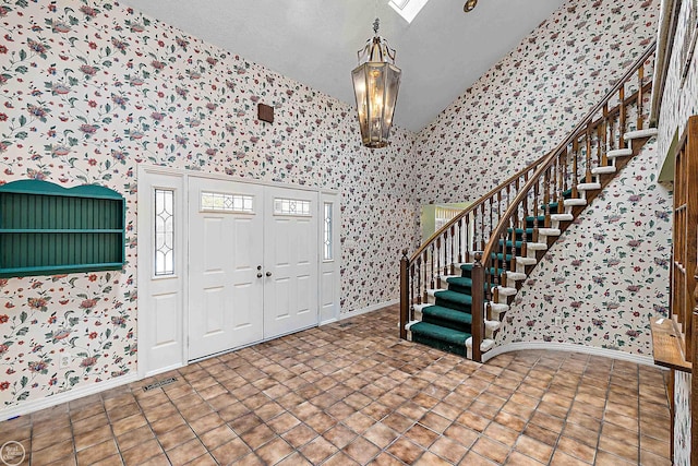 foyer with visible vents, baseboards, stairs, and wallpapered walls