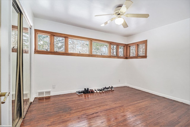 spare room with visible vents, baseboards, a healthy amount of sunlight, and hardwood / wood-style flooring