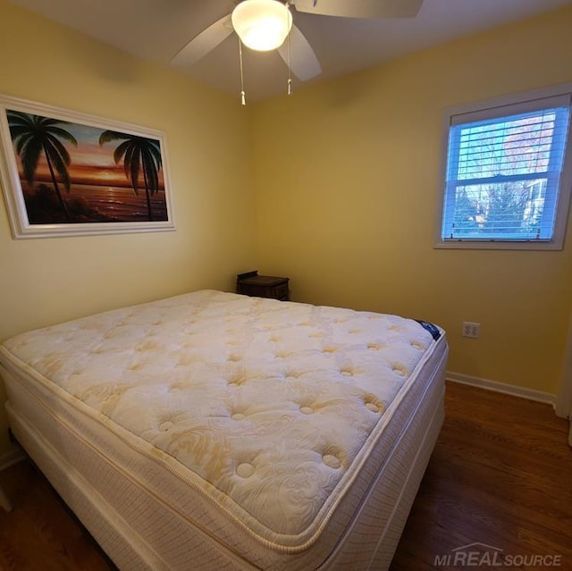 bedroom with baseboards, ceiling fan, and wood finished floors