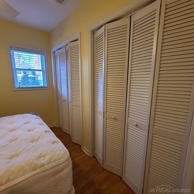 bedroom featuring wood finished floors and two closets