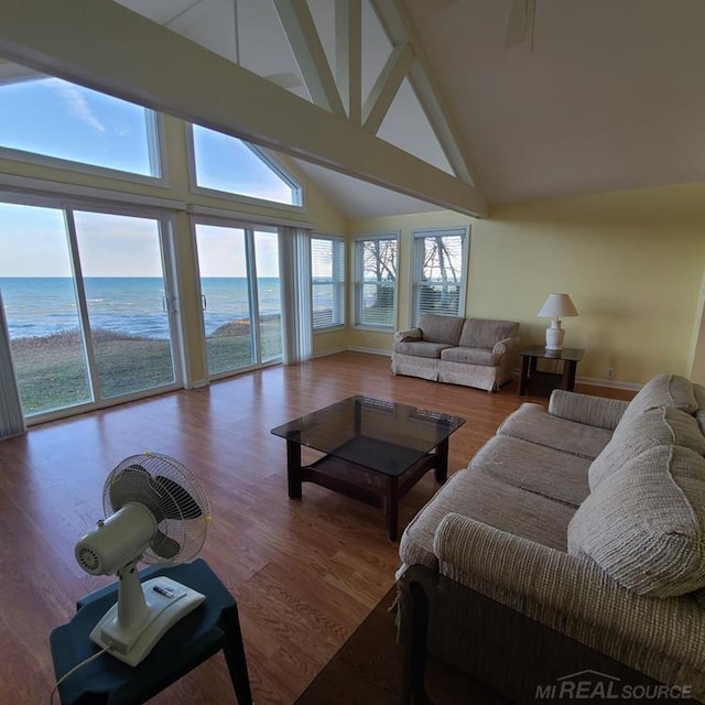 living room with wood finished floors, a water view, and high vaulted ceiling