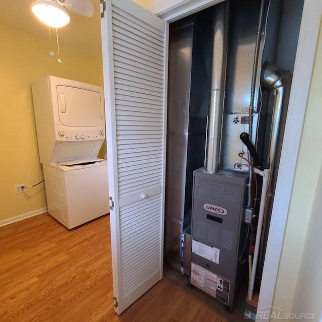 utilities featuring heating unit and stacked washer and dryer