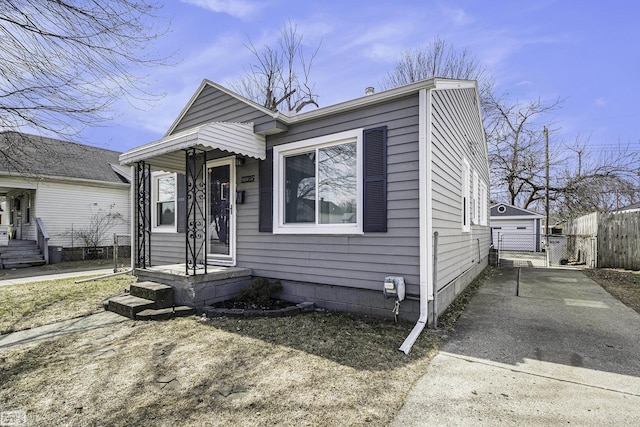 view of front of house with an outbuilding, a garage, and fence