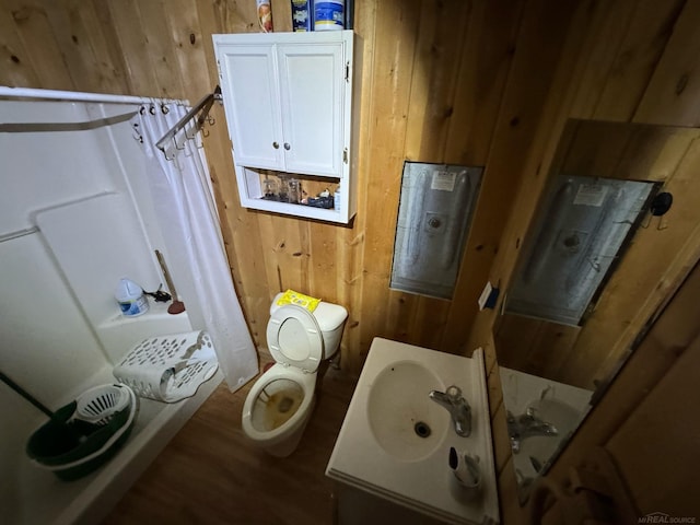 full bath featuring vanity, wooden walls, toilet, and wood finished floors