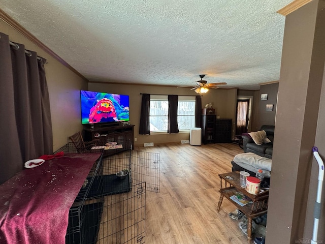 living room with ceiling fan, a textured ceiling, and wood finished floors