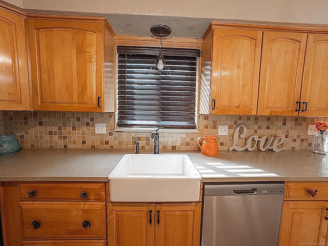 kitchen featuring a sink, stainless steel dishwasher, brown cabinetry, light countertops, and decorative backsplash