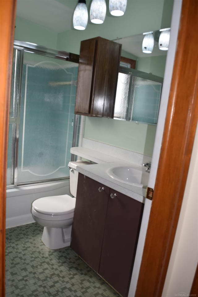 full bathroom with vanity, toilet, and bath / shower combo with glass door