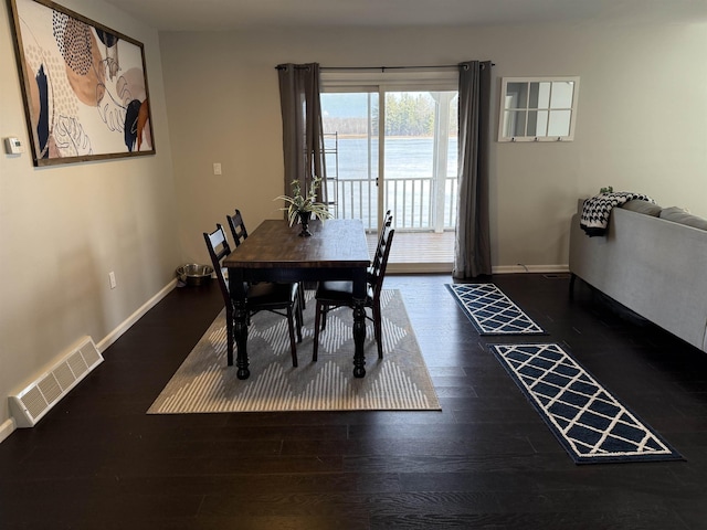 dining room featuring wood finished floors, visible vents, and baseboards