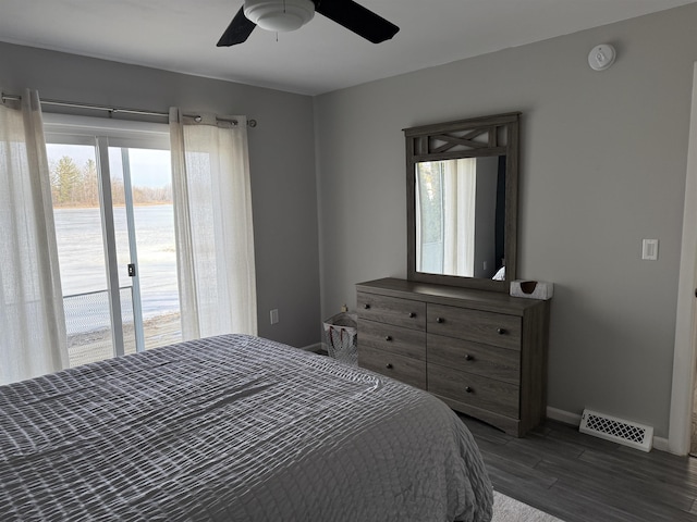 bedroom with a ceiling fan, wood finished floors, visible vents, baseboards, and access to exterior