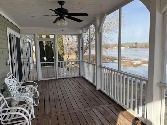 unfurnished sunroom featuring a water view and ceiling fan