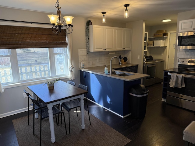 kitchen with washer and clothes dryer, white cabinets, stainless steel appliances, and a sink