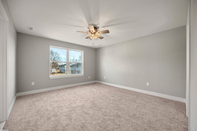 empty room featuring light carpet, visible vents, baseboards, and ceiling fan