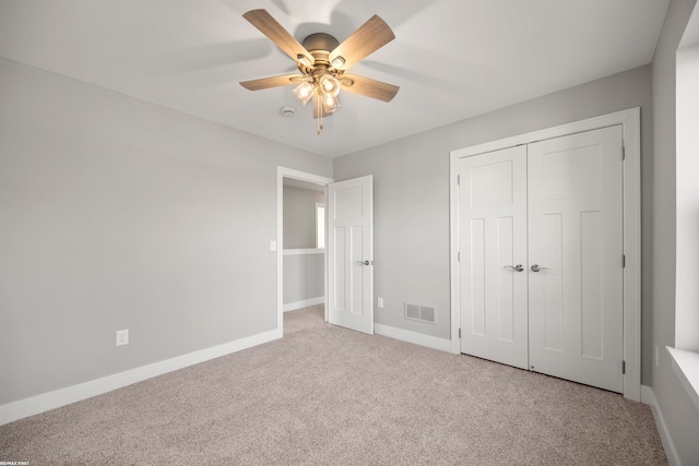 unfurnished bedroom with baseboards, visible vents, carpet floors, ceiling fan, and a closet