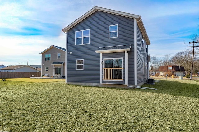 rear view of property with a lawn and central AC