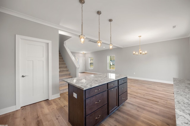 kitchen featuring visible vents, decorative light fixtures, light wood-style floors, dark brown cabinets, and a chandelier