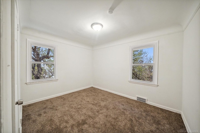 carpeted empty room featuring visible vents and baseboards