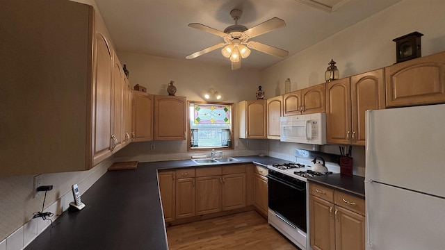 kitchen with white appliances, light wood-style floors, dark countertops, a sink, and a ceiling fan